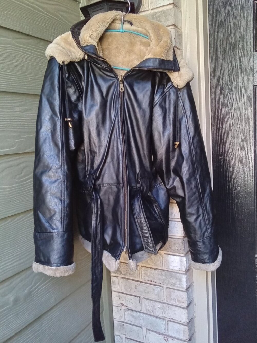 The VTG Wilda Genuine Leather Coat is a vintage 90s women's black hooded belted